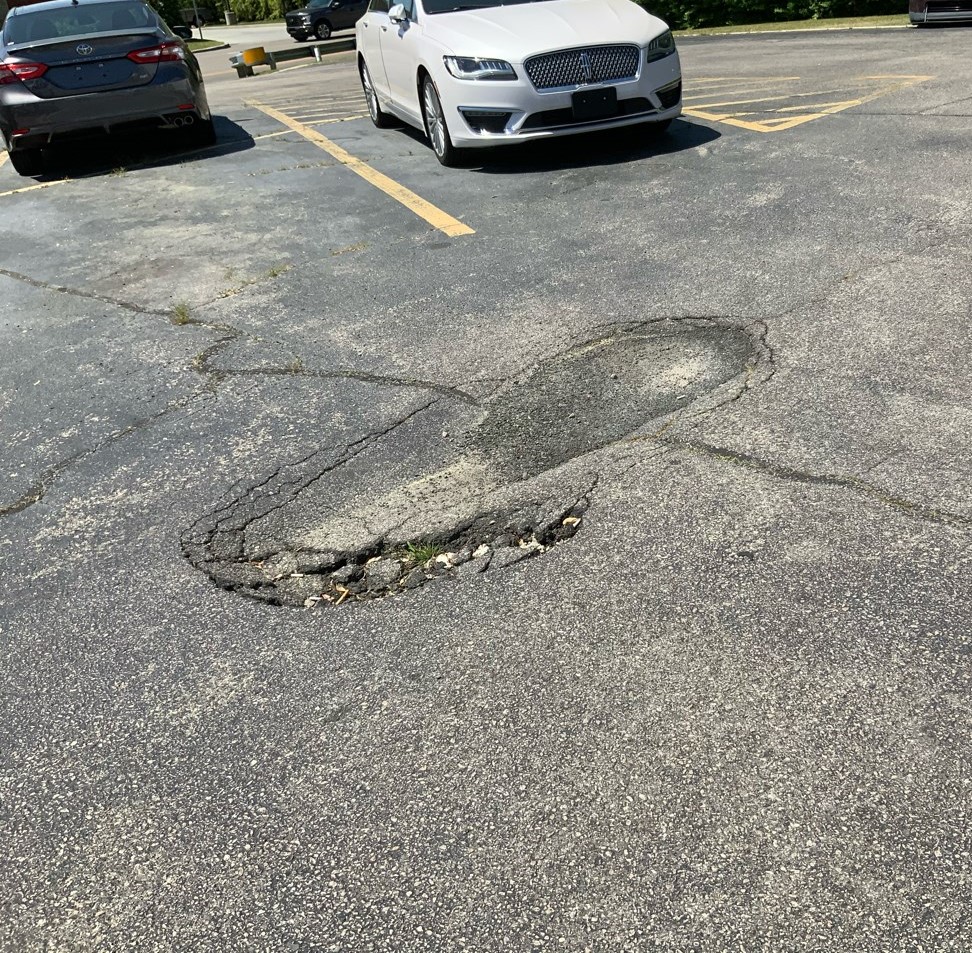 Good exterior dealership maintenance will repair this pothole which could injure customers and employees as well as damage cars.