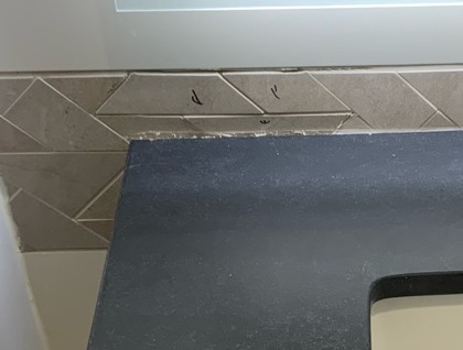 An example of poor-quality tile work right beside the washroom sink.  This is clearly visible to clients who use the washroom at this dealership