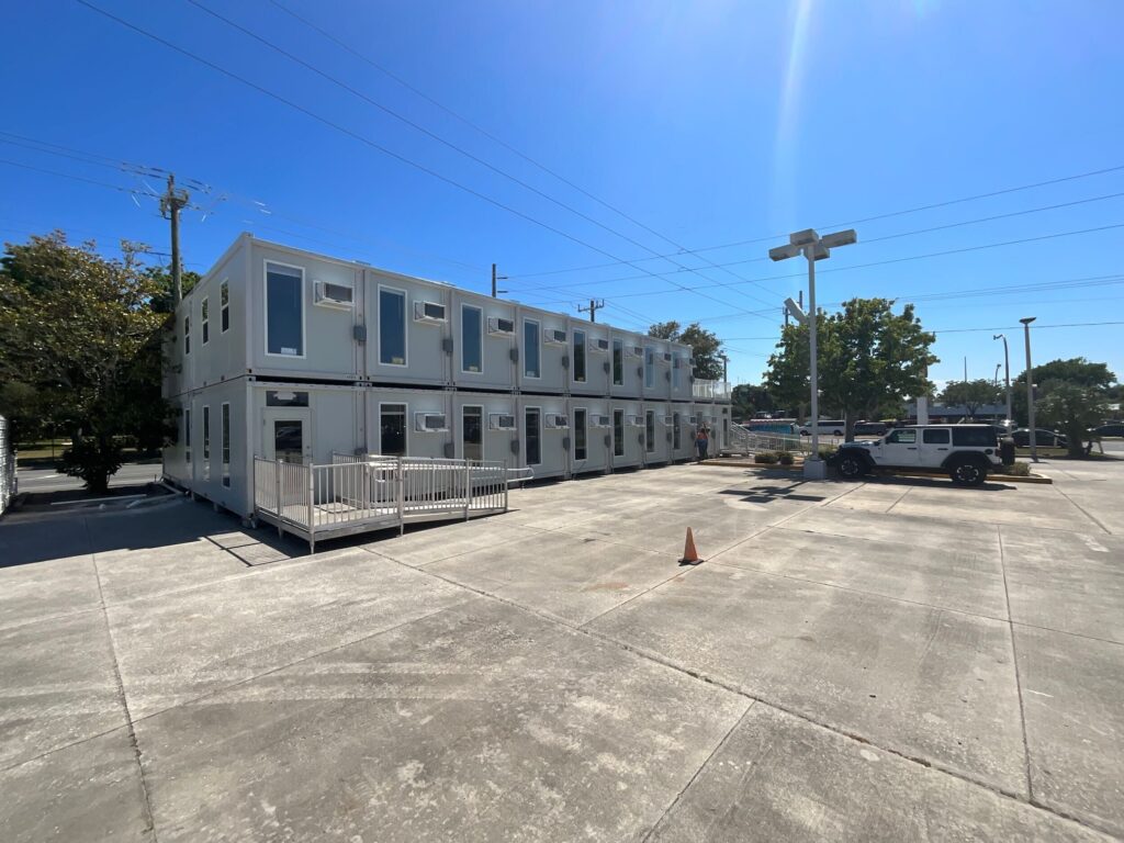 The two story modular office structure shows its large panes of glass and many air conditioning units to provide a comfortable work environment